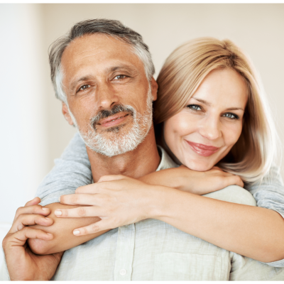 middle age couple embracing looking into camera